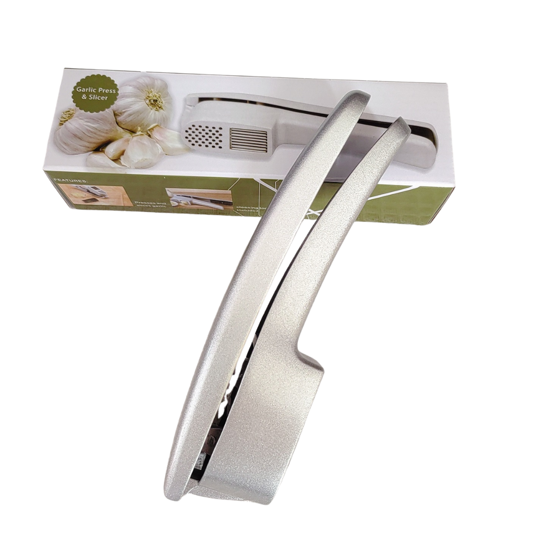 Knoblauchpresse in Silber liegt auf der Produktverpackung.